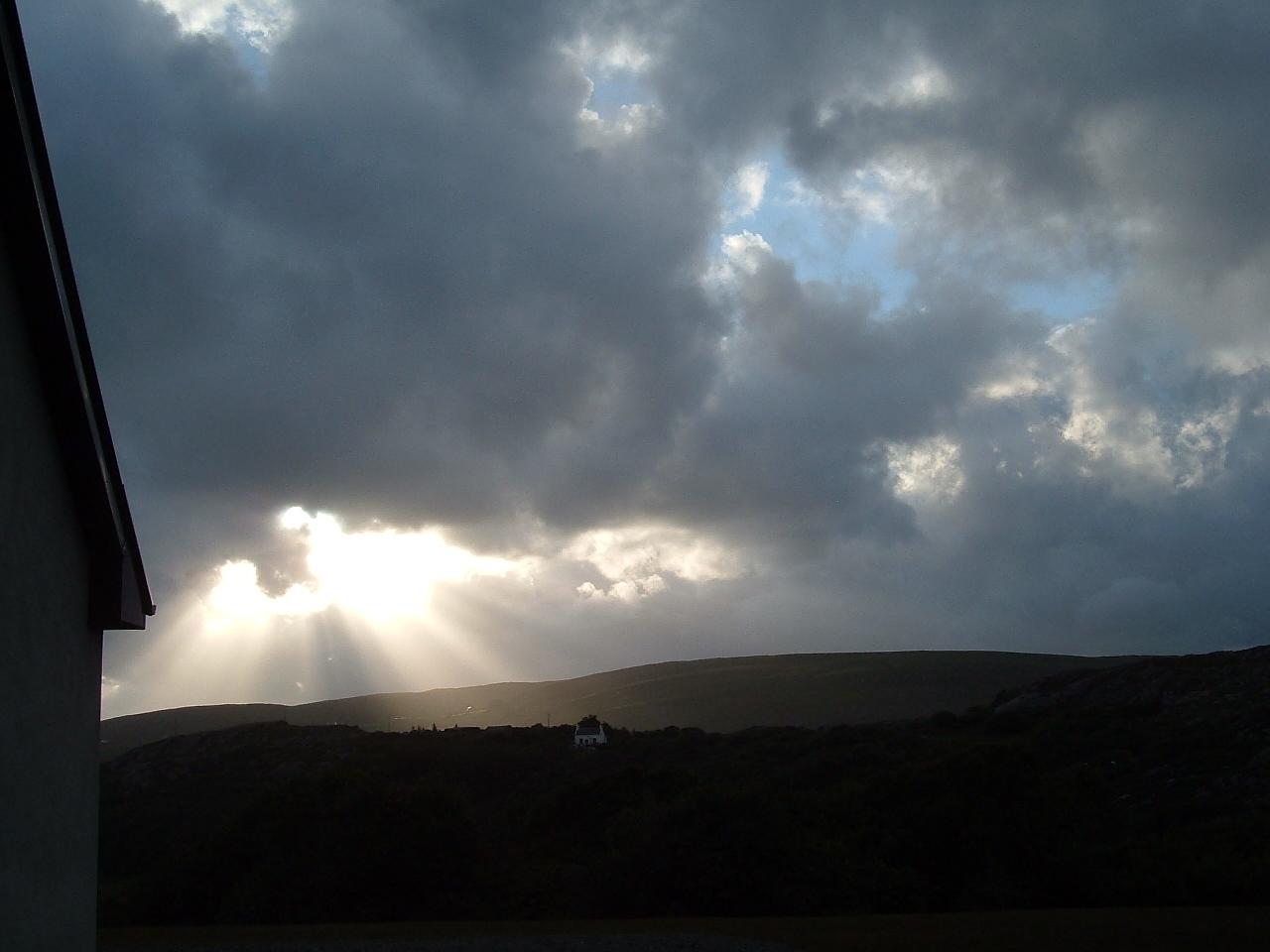 Light streams through clouds in a distant storm.