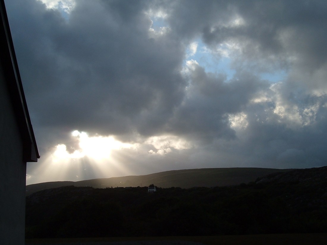 Light streams through clouds in a distant storm.