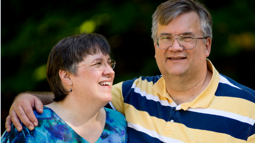 Image of laughing middle-aged couple shows what long-term love looks like.